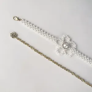 Détail de chaîne de taille fleur de perle avec strass et chaîne dorée délicate.