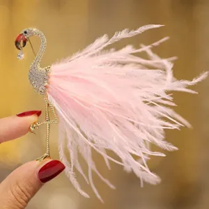 Exquisite flamingo brooch detail featuring sparkling rhinestones, gold tone and soft pink feathers.