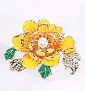 Exquisita broche con forma de flor de peonía amarilla, perla central y hojas con cristales.