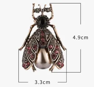 Detailed close-up of the vintage insect rhinestone brooch with pearl abdomen, elegant accessory.