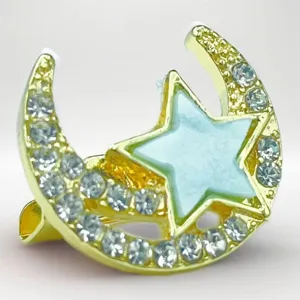 Gold crescent moon and star brooch detail showing sparkling rhinestones and blue enamel.