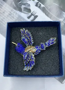 Detailaufnahme einer Vintage blauen Kristall Eisvogel Brosche in Geschenkbox, eleganter Schmuck.