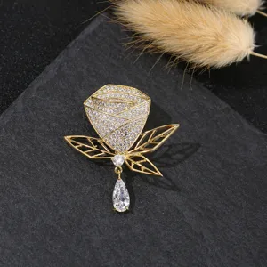 Nahaufnahme der eleganten vergoldeten Rosenbrosche mit funkelnden Zirkonia und Anhänger.