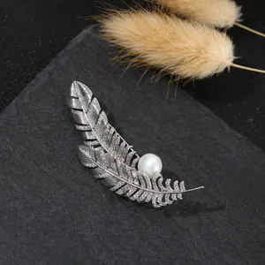Elegante silberne Feder Brosche mit Zirkon und Perle für stilvolle Damenbekleidung.