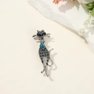 Vue détaillée d'une broche chat en strass bleu scintillant, idéale pour costumes et manteaux.