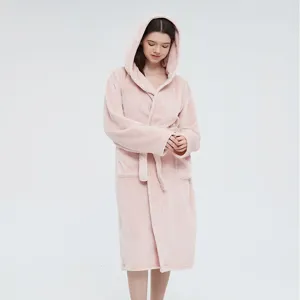 Vue détaillée de la couverture à capuche rose douce montrant le tissu moelleux et la coupe.