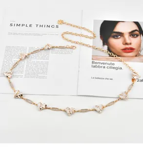 Gold metal chain belt featuring white enamel heart charms, chic sweet and cool waist accessory.