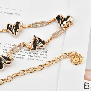 Gold metal waist chain with black enamel hearts, rhinestones, and flower pendant for dresses.