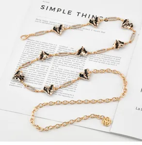 Detailed view of sweet cool heart metal waist chain with black oil drop and rhinestones.