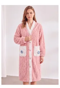 Dettaglio di vestaglia in pile rosa con tessuto soffice, finiture bianche e ricamo floreale.