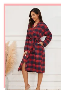 Détail du peignoir en flanelle à carreaux rouges et noirs, avec ceinture et manches longues.
