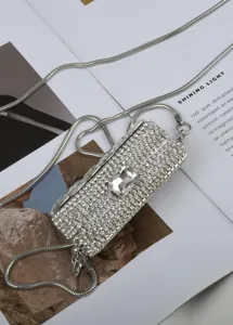 Gedetailleerde close-up van een glamoureuze strass mini taille tas en lichaam ketting.