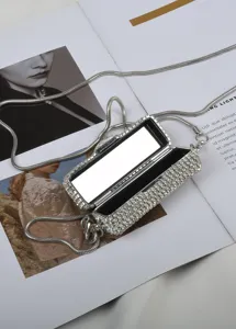 Gedetailleerd overzicht van een sprankelende strass mini tas met metalen riemstijl.
