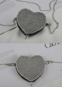 Close-up detail van de sprankelende strass hartvormige tassenriem met chique ketting.