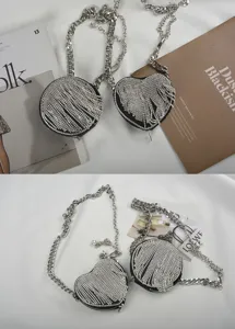 Vista detallada de minibolsos de cadena con flecos de estrás, formas redonda y de corazón.