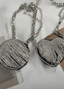 Bolso de cintura con pedrería brillante, bolsillos redondos y de corazón con cadenas.