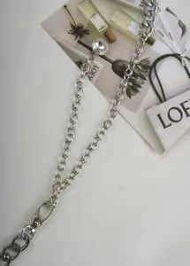 Accesorio de cadena de metal plateado con colgante de cristal para bolso o cintura detalle.