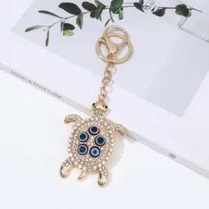 Gold alloy turtle keychain with sparkling rhinestones and evil eye beads detail view.
