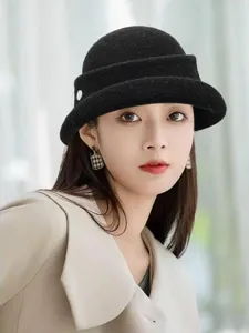 Gros plan élégant chapeau cloche en laine noire, texture douce et bord roulé chic pour l'hiver.