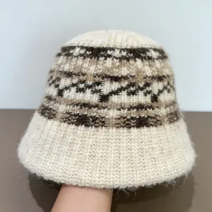 Close-up detail of the fuzzy knitted bucket hat featuring a cozy winter ethnic pattern.