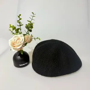 Dettaglio ravvicinato di berretto lavorato a maglia nero, stile retrò, morbida consistenza.