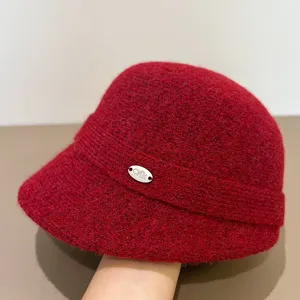 Close-up detail shot of red wool winter bucket hat, warm fisherman hat with metallic logo.