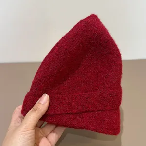 Detailed view of a stylish red woolen knitted fisherman hat, warm and cozy for autumn winter.