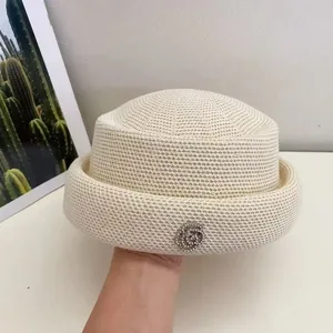Cappello a cuffia rétro elegante in maglia beige con bordo arrotolato e spilla camelia