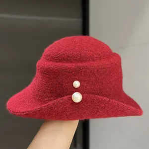Red wool bucket hat detail showing elegant roll brim and delicate double pearl decoration for autumn.