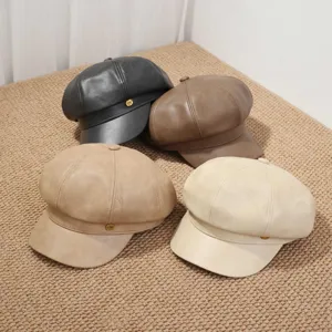 Vista detallada de cuatro gorras estilo marinero de cuero PU en negro, marrón, camello y beige.