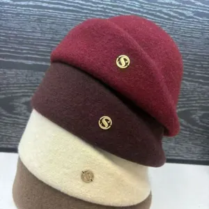 Detail shot of stylish women's wool-blend berets stacked neatly in multiple chic colors.