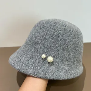 Grauer Plüsch Fischerhut Detail zeigt weiche Wolltextur und elegante Perlen Dekorationen.