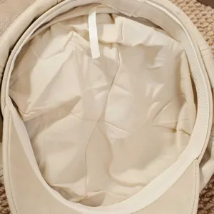 Detalle interior de la gorra newsboy de cuero PU beige, con forro fino y costuras.