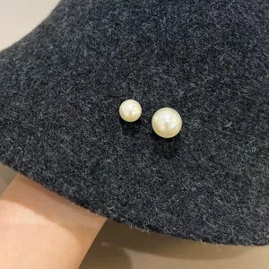 Nahaufnahme Detail eines eleganten dunkelgrauen Plüsch-Fischerhuts mit zwei Perlen.