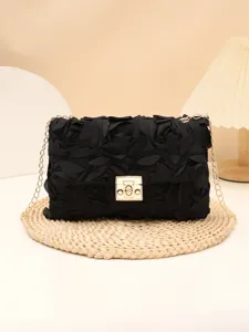 Detailed view of the elegant black floral texture evening shoulder bag with a gold chain strap.
