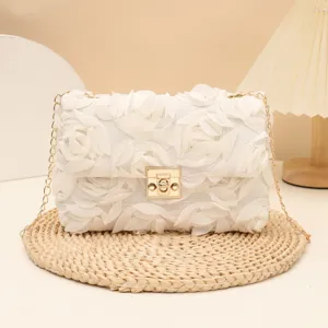 White fabric rose floral evening bag with gold chain strap and metal lock closure detail.