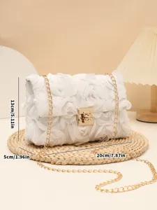 Detail shot of white floral evening crossbody bag with metal lock and chain strap.