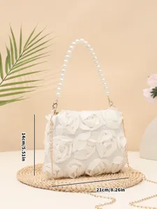 Detail view of the elegant floral handbag with pearl handle and gold chain strap.
