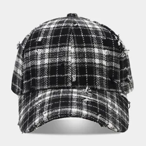 Black and white plaid distressed baseball cap detail, showing frayed edges and grunge texture.