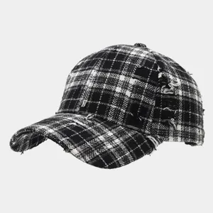 Detailed close-up view of the black and white plaid distressed baseball cap texture.