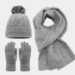 Conjunto de punto gris con gorro de pompón, bufanda acogedora y guantes táctiles.