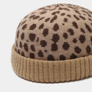 Primo piano di un berretto docker in maglia con stampa leopardata e risvolto a coste morbido.