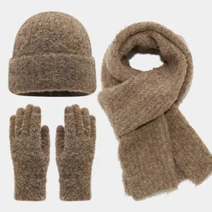 Vista detallada de la textura acogedora del gorro, la bufanda y los guantes de tejido bouclé.