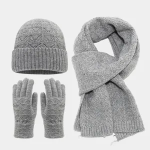 Detalle de tejido de punto gris con patrón de ondas y lentejuelas en gorro, bufanda y guantes.
