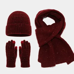 Vista detallada del set de invierno rojo oscuro con gorro, bufanda y guantes de lentejuelas.