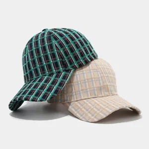 Detailed view of vintage plaid baseball hats in green and beige, cozy autumn winter styles.