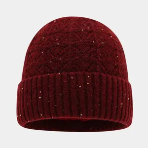 Vista detallada del gorro de punto rojo oscuro con lentejuelas brillantes para invierno.