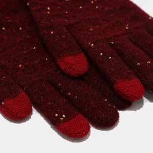 Primer plano detallado de guantes de punto rojo oscuro con lentejuelas y dedos táctiles.