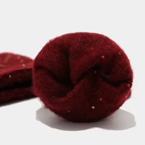 Primer plano de los detalles del conjunto de invierno de lana tejida en rojo oscuro.