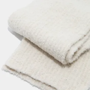 Primer plano detallado del tejido de bufanda de invierno crema suave y esponjoso.